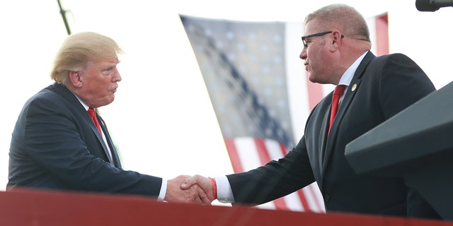 Illinois Gubernatorial hopeful Darren Bailey greets Donald Trump after receiving an endorsement during a Save America Rally with former U.S. President Donald Trump at the Adams County Fairgrounds on June 25, 2022 in Mendon, Illinois. 