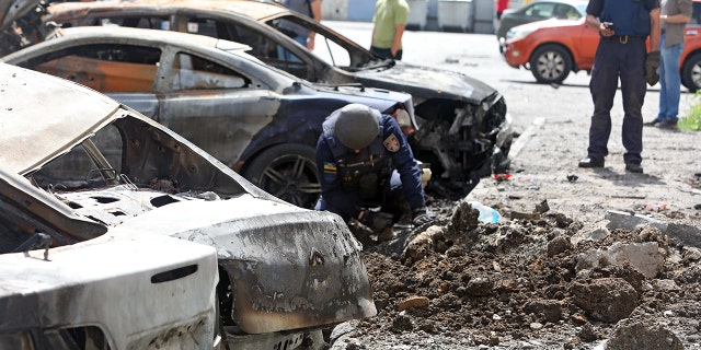 A State Emergency Service employee partakes in the response effort to the shelling of a northern neighborhood by Russian troops with a BM-30 Smerch multiple rocket launcher, Kharkiv, northeastern Ukraine.