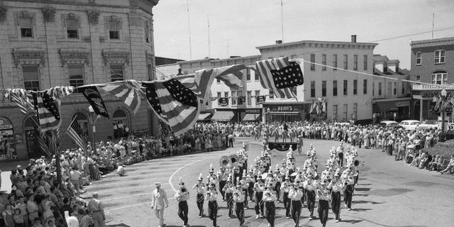 Onlookers watch a 4th of July parade and marching band in Gettysburg, Pennsylvania, circa 1950.