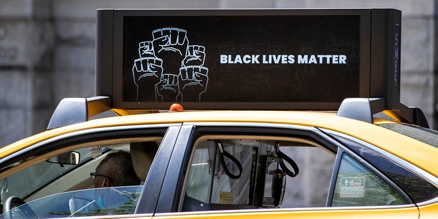 NYC yellow cab has a digital sign on its roof that reads, "Black Lives Matter" with multiple black power fists in a circle as it drives down Central Park West photographed in Manhattan on June 12, 2020. 