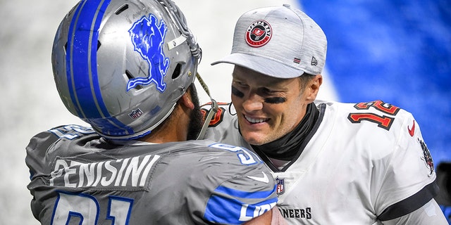 Tom Brady (12) of the Tampa Bay Buccaneers embraces John Penisini (91) of the Detroit Lions after a game at Ford Field Dec. 26, 2020, in Detroit. 