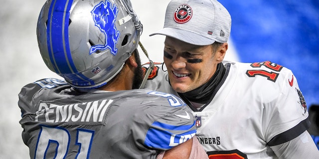 Tom Brady (12) of the Tampa Bay Buccaneers embraces John Penisini (91) of the Detroit Lions after a game at Ford Field Dec. 26, 2020, in Detroit.