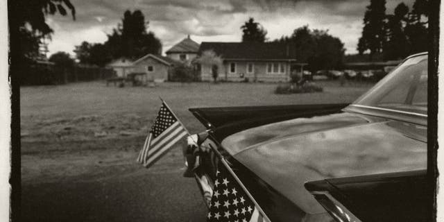 A car shows off two American flags before a July 4th parade in Carnation, Washington, circa 1990.