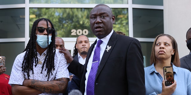 Benjamin Crump, one of the lawyers representing the family of Andrew Brown Jr., stands with Mr. Brown's son Khalil Ferebee as he speaks during a press conference on April 27, 2021, in Elizabeth City, North Carolina. 