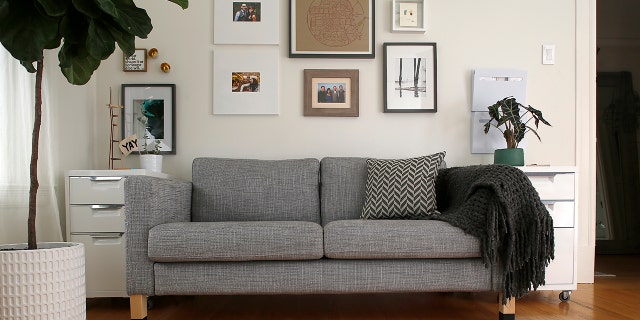 Sofa and gallery seen in the home office of founder and lead designer Gina Gutierrez of Gina Rachelle Design.