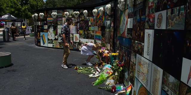 Johanna Parker of Orlando leaves a bouquet of fresh flowers at the Pulse nightclub memorial on June12, 2021, in Orlando, Florida. 