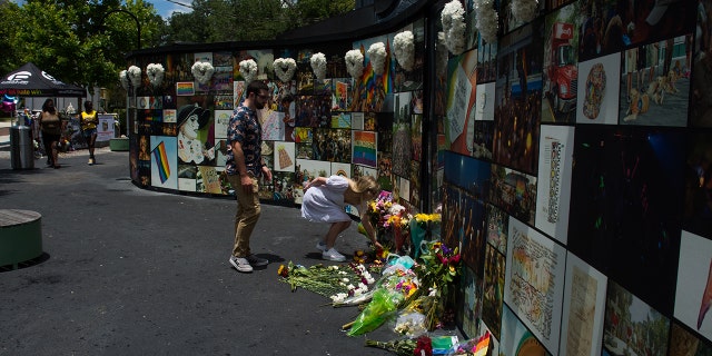 Johanna Parker of Orlando leaves a bouquet of fresh flowers at the Pulse nightclub memorial on June12, 2021, in Orlando, Florida. 