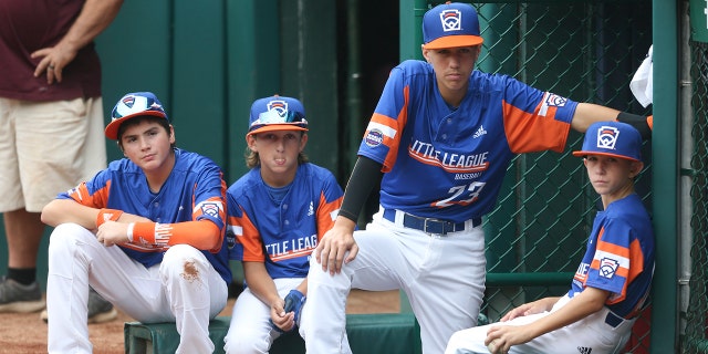 WILLIAMSPORT, PENNSYLVANIA - AUGUST 29: Team Michigan players sit outside the dugout before the 2021 Little League World Series game against Team Ohio at Howard J. Lamade Stadium on August 29, 2021, in Williamsport, Pennsylvania. 