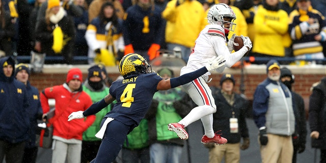 Ohio State Buckeyes' Garret Wilson # 5 catches a pass as Vincent Gray # 4 of Michigan Wolverins defends in the fourth quarter during a match at Michigan Stadium in Ann Arbor, Michigan on November 27, 2021. Did. 
