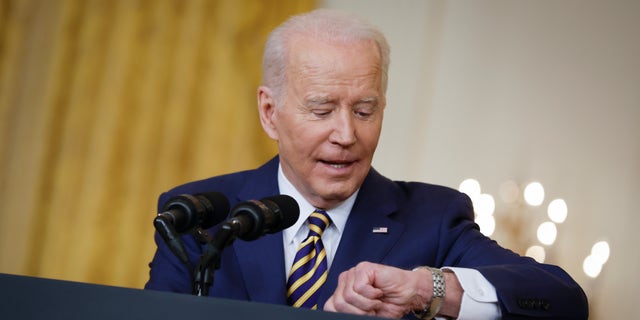 WASHINGTON, DC - JANUARY 19: U.S. President Joe Biden checks his watch while answering questions during a news conference in the East Room of the White House on January 19, 2022 in Washington, DC. With his approval rating hovering around 42-percent, Biden is approaching the end of his first year in the Oval Office with inflation rising, COVID-19 surging and his legislative agenda stalled on Capitol Hill. (Photo by Chip Somodevilla/Getty Images)