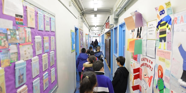 Students are led to their classroom at Yung Wing School P.S. 124 on March 07, 2022 in New York City. 