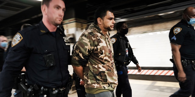 Police detain a man at a Times Square subway station following a call to police from riders on April 25, 2022, in New York City.