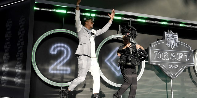 Garrett Wilson celebrates onstage after being selected tenth by the New York Jets during round one of the 2022 NFL Draft on April 28, 2022 a Las Vegas, Nevada. 