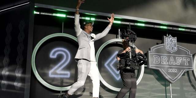 Garrett Wilson celebrates onstage after being selected tenth by the New York Jets during round one of the 2022 NFL Draft on April 28, 2022 in Las Vegas, Nevada. 