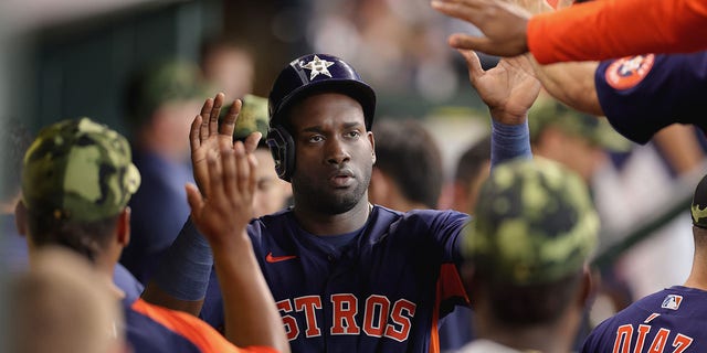 Yordan Alvarez #44 of the Houston Astros high fives teammates after being driven in on a double hit by Yuli Gurriel #10 during the fifth inning against the Texas Rangers at Minute Maid Park on May 22, 2022 in Houston, Texas. 