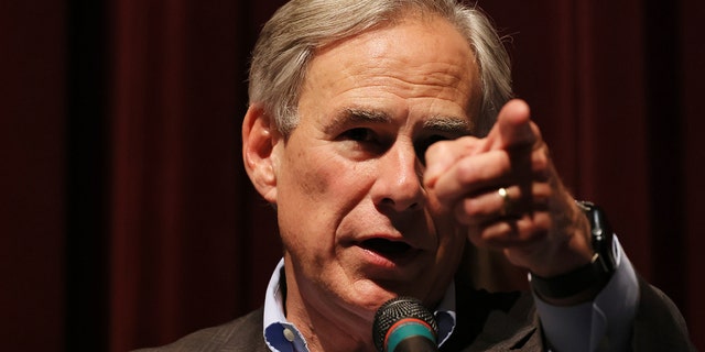 Gov. Greg Abbott points to a reporter during a press conference.