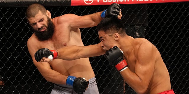 (R-L) Zhang Mingyang of China punches Tuco Tokkos of England during the Road to UFC event at Singapore Indoor Stadium on June 09, 2022 in Singapore. 