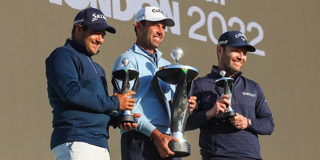 Charl Schwartzel of Stinger GC celebrates with the LIV Golf Invitational Individual trophy alongside teammates Hennie du Plessis (L) and Branden Grace (R) who hold their runner's up trophies during day three of LIV Golf Invitational - London at The Centurion Club on June 11, 2022 in St Albans, England. 