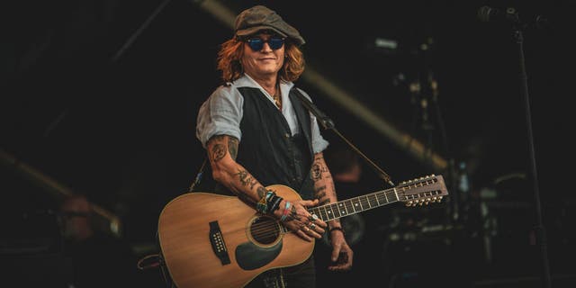 Johnny Depp performs on stage with Jeff Beck (not pictured) during the Helsinki Blues Festival in Kaisaniemi Puisto on June 19, 2022 in Helsinki.