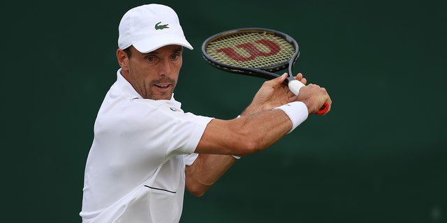 Roberto Bautista Agut, of Spain, plays a backhand against Attila Balazs, of Hungary, during their Men's Singles First Round Match on day two of The Championships Wimbledon 2022 at All England Lawn Tennis and Croquet Club on June 28, 2022 in London, England. 