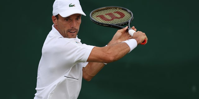 Roberto Bautista Agut, of Spain, plays a backhand against Attila Balazs, of Hungary, during their Men's Singles First Round Match on day two of The Championships Wimbledon 2022 at All England Lawn Tennis and Croquet Club on June 28, 2022 in London, England. 