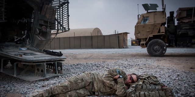 A soldier in the U.S. Army's 1st Battalion, 36th Infantry Regiment, Charlie Company is shown napping during a maintenance stop at Forward Operating Base Azzizulah in March 2013, in Kandahar Province, Maiwand District, Afganistán. 