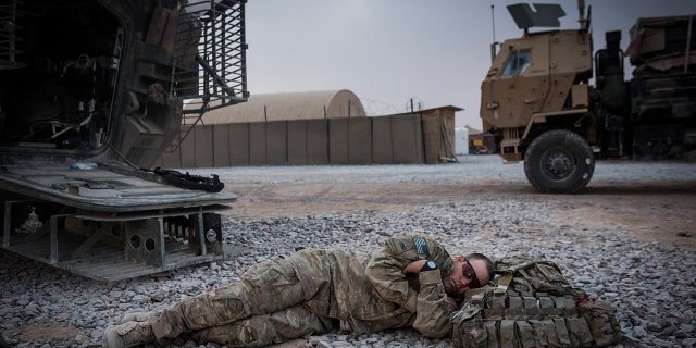 A soldier in the U.S. Army's 1st Battalion, 36th Infantry Regiment, Charlie Company is shown napping during a maintenance stop at Forward Operating Base Azzizulah in March 2013, in Kandahar Province, Maiwand District, Afghanistan.