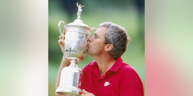 Curtis Strange kisses the U.S. Open trophy at the Oak Hill Country Club in Rochester, New York, in 1989.