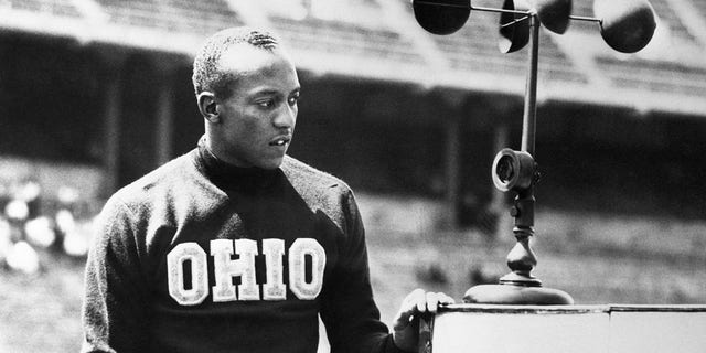 Jesse Owens, Ohio State's ace sprinter, is shown after breaking the world record in the 220-yard dash at the 36th annual Western Conference track and field meet at Columbus, Ohio, when he stepped the event in 21.1. The old mark for the 220 around one turn was 21.2 set in 1933 by Ralph Metcalfe, Marquette's dusky speedster. Owens also won the 100-yard dash.