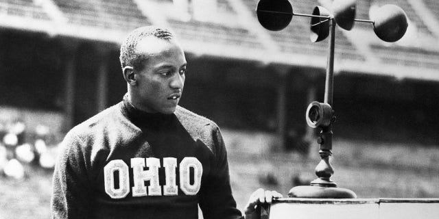 Jesse Owens, Ohio State's ace sprinter, is shown after breaking the world record in the 220-yard dash at the 36th annual Western Conference track and field meet at Columbus, Ohio, when he stepped the event in 21.1. The old mark for the 220 around one turn was 21.2 set in 1933 by Ralph Metcalfe, Marquette's dusky speedster. Owens also won the 100-yard dash.