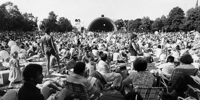 A massive crowd gathers to watch a 4th of July performance at the Hatch Memorial Shell in Boston, circa 1980.