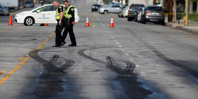 Bu görüntü, LAPD müfettişlerinin, 26 Şubat 2015'te Chatsworth'te Plummer Caddesi'nde işlenen bir suçtan sonra kaçan bir Ford Mustang sürücüsü tarafından iki yayanın öldürüldüğü bir drag yarışı alanındaki kızak izlerini incelediğini gösteriyor.