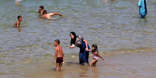 Algerian women wear a "burkini" in the sea at the beach of Oran, West of Algiers on Aug. 5, 2017. 