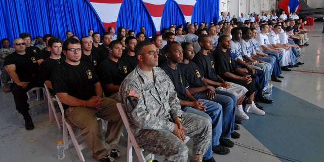 U.S. Army recruiter Sgt. Neil Grullon, front left, sits with the 121 recruits from the five U.S. military services, sworn in by Air Force Lt. General Craig McKinley at a hangar in Opa-loca, Florida, Thursday, May 3, 2007. 