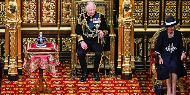 Prince Charles and Camilla, Duchess of Cornwall, sit by The Imperial State Crown in the House of Lords Chamber, during the State Opening of Parliament on May 10, 2022, in London.