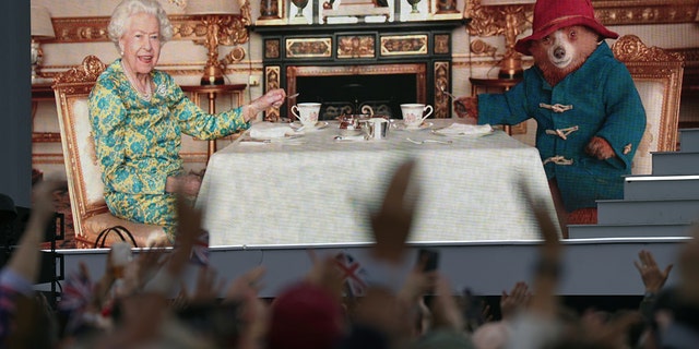 Queen Elizabeth II has tea with Paddington Bear on a big screen during the "Platinum Party at the Palace" stage in front of Buckingham Palace, London, on June 4, 2022.
