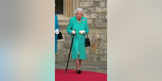 Britain's Queen Elizabeth II prepares to touch the Commonwealth Nations Globe to start the lighting of the Principal Beacon outside of Buckingham Palace in London, from the Quadrangle at Windsor Castle in Windsor, west of London, as part of Platinum Jubilee celebrations on June 2, 2022, in Windsor, England. 