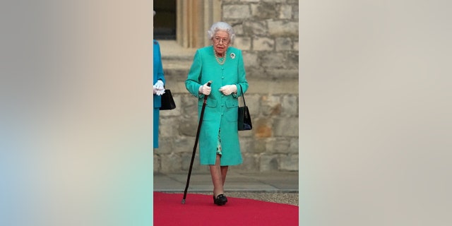 Britain's Queen Elizabeth II prepares to touch the Commonwealth Nations Globe to start the lighting of the Principal Beacon outside of Buckingham Palace in London, from the Quadrangle at Windsor Castle in Windsor, west of London, as part of Platinum Jubilee celebrations on June 2, 2022, in Windsor, England.