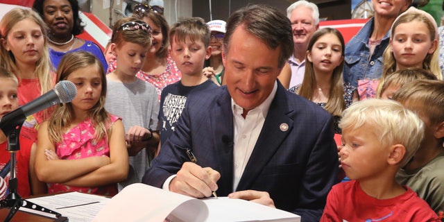 Virginia Gov. Glenn Youngkin signs the budget at a ceremony at a grocery store Tuesday June 21, 2022, in Richmond, Va. The Virginia General Assembly passed the budget earlier in the week.