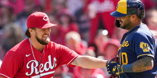 Milwaukee Brewers' Omar Narvaez, right, grounds out softly to Cincinnati Reds starting pitcher Graham Ashcraft, left, during the second inning of a baseball game Saturday, June 18, 2022, in Cincinnati. 