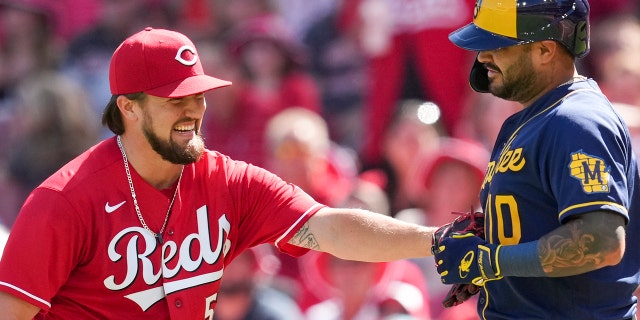 Milwaukee Brewers' Omar Narvaez, right, grounds out softly to Cincinnati Reds starting pitcher Graham Ashcraft, left, during the second inning of a baseball game Saturday, June 18, 2022, in Cincinnati.