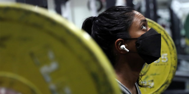 FILE - Anandi Cade lifts weights at Fitness SF on Fillmore Street in San Francisco, Dec. 29, 2021. 