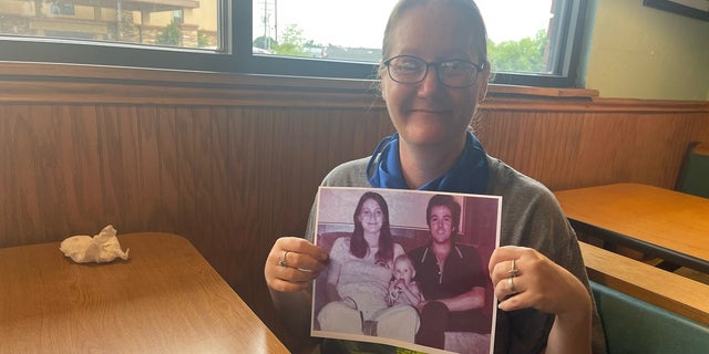 Holly Clouse, a.k.a. "Baby Holly" photographed holding a picture of her parents more than 40 years after investigators located her alive