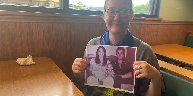 Holly Clouse, a.k.a. "Baby Holly" photographed holding a picture of her parents more than 40 years after investigators located her alive
