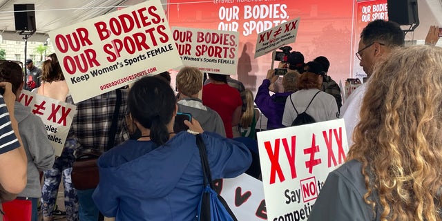 Los asistentes al mitin sostienen carteles en el "Nuestro cuerpo, nuestro deporte" Manifestación en Washington, D.C. 