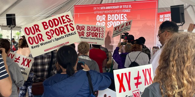 Los asistentes al mitin sostienen carteles en el "Nuestro cuerpo, nuestro deporte" Manifestación en Washington, D.C.