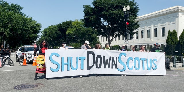 Activists hold up a "Shut down SCOTUS" sign near the Supreme Court during a protest in June.