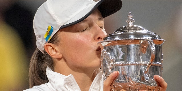 Iga Swiatek of Poland with the winner's trophy after her victory over Coco Gauff of the United States in the women's singles final on Court Philippe Chatrier at the 2022 French Open at Roland Garros June 4, 2022, in Paris.