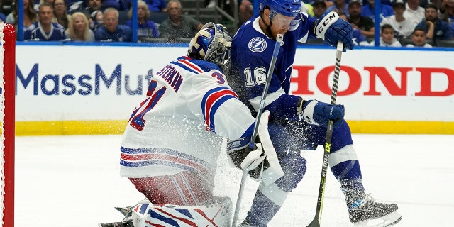 Tampa Bay Lightning center Riley Nash (16) crashes into New York Rangers goaltender Igor Shesterkin (31) during the second period in Game 3 of the NHL hockey Stanley Cup playoffs Eastern Conference finals Sunday, June 5, 2022, in Tampa, Fla. Nash was called for a penalty on the play.