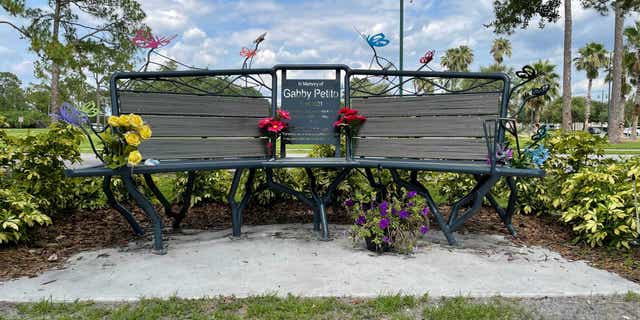 Gabby Petito memorial bench in Florida adorned with flowers. It was installed near where a temporary makeshift memorial had existed for months as police desperately searched for Petito and then Brian Laundrie.